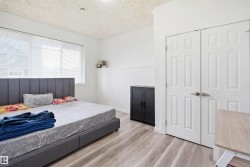 Room featuring a wide window with blinds, light wood-finish flooring, and white paneled doors - 