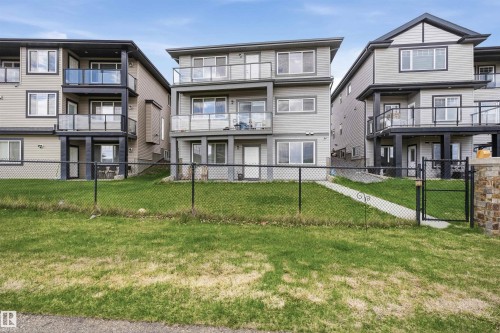 Contemporary multi-level exterior featuring multiple balconies with glass railings, light gray siding, and dark trim accents - 3909 49 Ave, Beaumont, AB - Outdoor With Facade