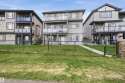 Contemporary multi-level exterior featuring multiple balconies with glass railings, light gray siding, and dark trim accents - 