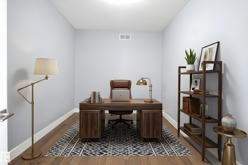 Dedicated room featuring wood-finish flooring, light gray walls, white baseboards, and a white ceiling with a flush-mount light fixture - 3909 49 Ave, Beaumont, AB - Indoor Photo Showing Office