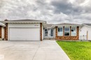 Single-story residence featuring a brick and white siding exterior, an attached two-car garage, multiple front-facing windows, a concrete driveway, and a front lawn - 14123 96 Street, Edmonton, AB 