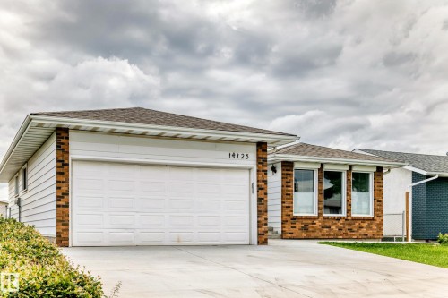 Ranch-style residence featuring a two-car garage, brick accents, and light-colored siding - 14123 96 Street, Edmonton, AB 