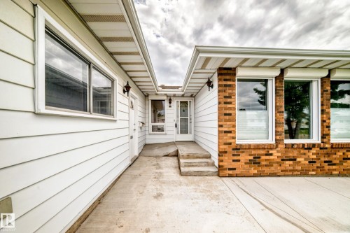 Exterior featuring a blend of white horizontal siding and multi-toned brickwork - 14123 96 Street, Edmonton, AB 