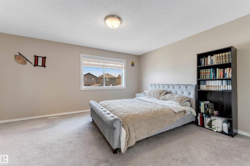 Carpeted room featuring a ceiling-mounted light fixture, a window with roller shades, and light-toned wall finishes - 121 64 Street, Edmonton, AB - Indoor Photo Showing Bedroom