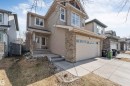 Two-story residence featuring light-toned siding, a brick facade, and an attached two-car garage with transom windows - 121 64 Street, Edmonton, AB  - Outdoor 