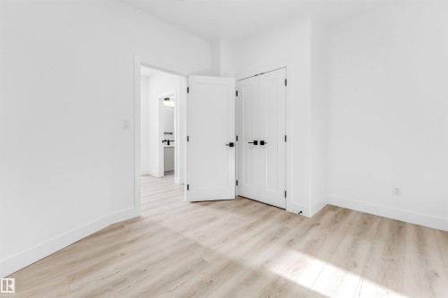 The room features light-toned flooring and white walls, complemented by white doors with black hardware - 4102 67 Street, Beaumont, AB - Indoor Photo Showing Other Room