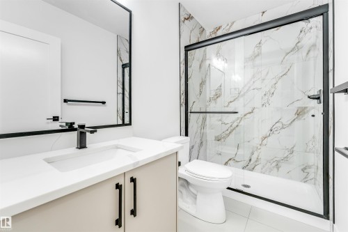 Bathroom featuring a spacious vanity with a white countertop, a shower with a clear glass enclosure and marble-look wall tiles, and white floor tiles - 4102 67 Street, Beaumont, AB - Indoor Photo Showing Bathroom