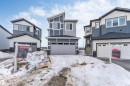 The property features a modern exterior with a grey and white color scheme, an attached garage, and multiple windows - 4102 67 Street, Beaumont, AB  - Outdoor With Facade 