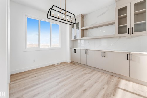 Bright interior space featuring light-toned flooring and white walls - 4102 67 Street, Beaumont, AB - Indoor