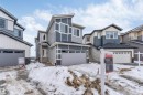 Modern property featuring a two-car garage, grey siding, and a prominent front door with steps - 4102 67 Street, Beaumont, AB  - Outdoor With Facade 