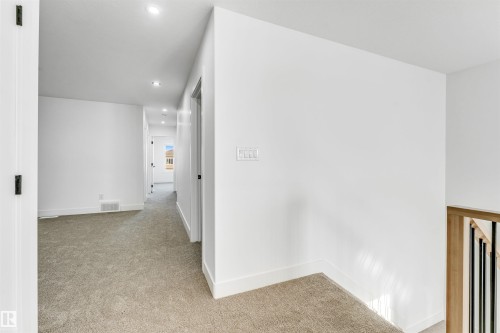 The property offers an interior with light-colored carpeting, white walls, and recessed lighting - 4102 67 Street, Beaumont, AB - Indoor Photo Showing Other Room