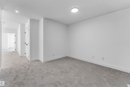 Room featuring light grey carpet flooring, white walls, and a modern flush mount ceiling light - 4102 67 Street, Beaumont, AB - Indoor Photo Showing Other Room
