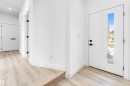 Welcoming entry with light-toned flooring, white walls, and a front door featuring a vertical window panel - 4102 67 Street, Beaumont, AB  - Indoor Photo Showing Other Room 