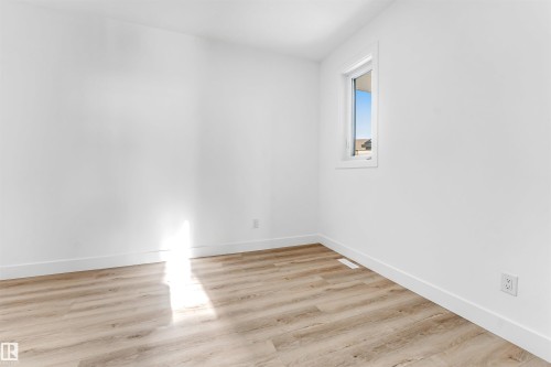 This room features light wood-look flooring and white walls, creating a bright and airy atmosphere - 4102 67 Street, Beaumont, AB - Indoor Photo Showing Other Room