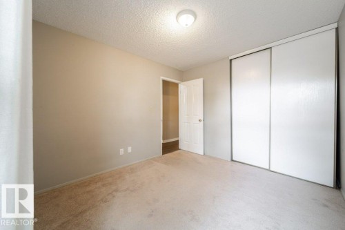 Wall-to-wall carpeting and neutral wall tones create a versatile interior - 17106 108 St Nw, Edmonton, AB - Indoor Photo Showing Other Room