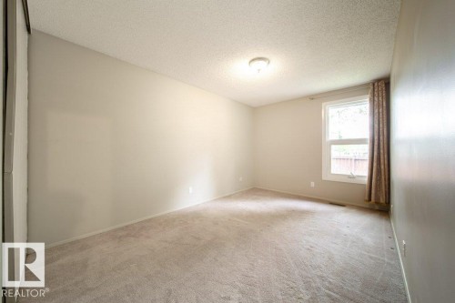 Neutral-toned walls and carpeting create a versatile interior space - 17106 108 St Nw, Edmonton, AB - Indoor Photo Showing Other Room