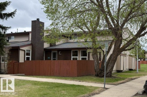 Townhome-style exterior with beige siding and brick accents - 17106 108 St Nw, Edmonton, AB - Outdoor