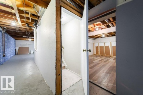 Unfinished basement featuring exposed overhead joists and concrete flooring - 17106 108 St Nw, Edmonton, AB - Indoor