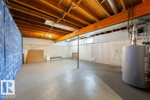 Spacious unfinished basement with exposed wood joists and support beams, featuring a concrete floor, perimeter wall insulation, and a water heater - 17106 108 St Nw, Edmonton, AB - Indoor Photo Showing Basement