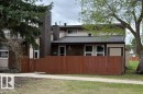 Two-story residence featuring a brown wood fence, tan siding, and a dark shingle roof - 17106 108 St Nw, Edmonton, AB  - Outdoor 