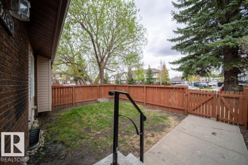 Private outdoor space featuring a wood fence, concrete patio, and a grass area - 17106 108 St Nw, Edmonton, AB - Outdoor