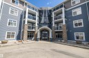 Multi-story building with blue siding and stone facade accents - 406 16035 132 Street, Edmonton, AB  - Outdoor With Balcony With Facade 