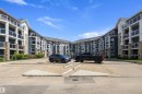 Multi-story residential building featuring dark blue siding, white trim, and stone accents - 406 16035 132 Street, Edmonton, AB  - Outdoor With Balcony With Facade 