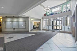 Spacious lobby entrance featuring a vaulted ceiling and a modern chandelier - 