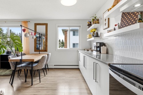 Kitchen and dining area featuring wood-finish flooring - 217 14819 51 Avenue, Edmonton, AB - Indoor