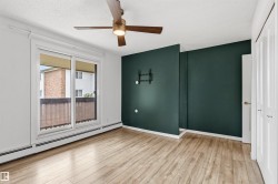 Room featuring light wood-finish flooring, a contemporary ceiling fan, and a sliding glass door opening to an exterior space - 