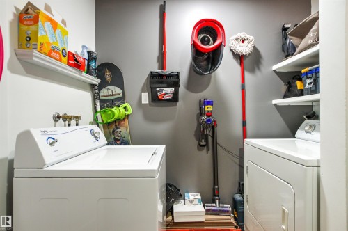 Dedicated laundry area featuring a top-loading washing machine and front-loading dryer - 217 14819 51 Avenue, Edmonton, AB - Indoor Photo Showing Laundry Room