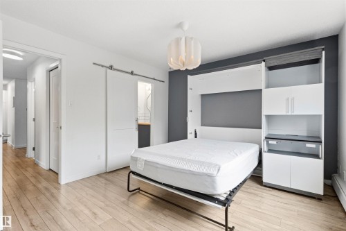 Integrated wall unit with a fold-down bed, built-in cabinetry, and shelving - 217 14819 51 Avenue, Edmonton, AB 
