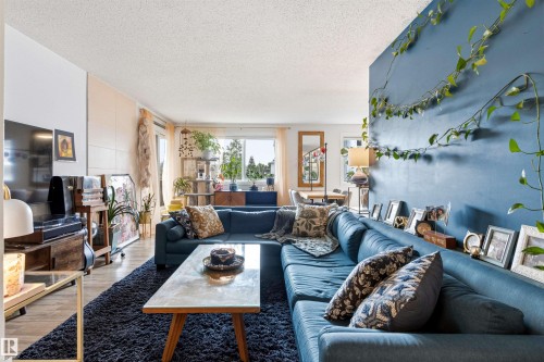 Open-concept living space with large windows providing ample natural light - 217 14819 51 Avenue, Edmonton, AB - Indoor Photo Showing Living Room
