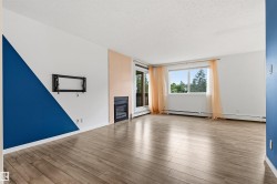 Spacious interior featuring wood-finish flooring, a contemporary accent wall, and a built-in fireplace - 