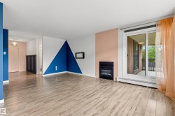 Living area featuring wood-finish flooring, a built-in fireplace, and a sliding glass door - 