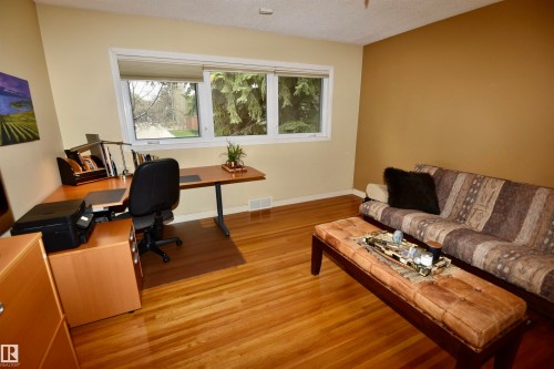 Spacious room featuring wood-finish flooring, a large window, and light-toned walls - 13910 101A Avenue, Edmonton, AB - Indoor Photo Showing Living Room