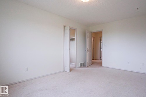 Neutral-toned carpeting and walls provide a versatile canvas - 1627 Melrose Place Sw, Edmonton, AB - Indoor Photo Showing Other Room
