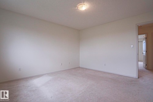 Carpeted room with neutral wall paint - 1627 Melrose Place Sw, Edmonton, AB - Indoor Photo Showing Other Room