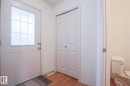 Entryway featuring wood-finish flooring, white paneled doors, and a front door with a decorative glass insert - 1627 Melrose Place Sw, Edmonton, AB  - Indoor Photo Showing Other Room 