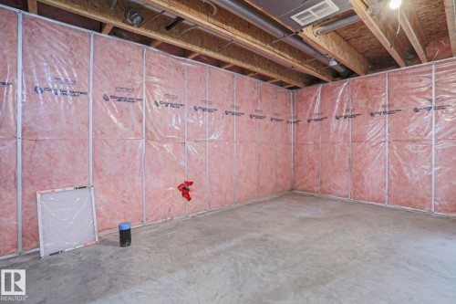 Unfinished lower level with concrete flooring, framed and insulated walls, exposed ceiling joists, and visible utility lines - 1627 Melrose Place Sw, Edmonton, AB - Indoor Photo Showing Basement