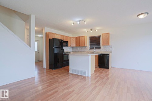 Open-concept living area featuring wood-finish flooring - 1627 Melrose Place Sw, Edmonton, AB - Indoor Photo Showing Kitchen