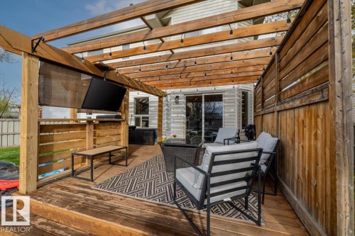 Spacious outdoor deck featuring a wooden pergola, built-in wooden privacy screen, and string lights - 3570 Mclean Crescent, Edmonton, AB - Outdoor With Deck Patio Veranda With Exterior