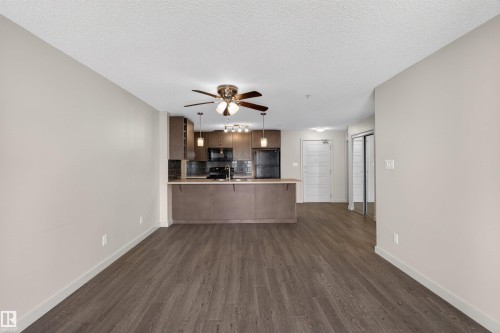 Open-concept living space featuring wood-finish flooring - 215 6084 Stanton Drive, Edmonton, AB - Indoor Photo Showing Kitchen