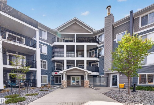 Multi-story building featuring a central entrance with a stone-clad portico - 215 6084 Stanton Drive, Edmonton, AB - Outdoor With Balcony With Facade