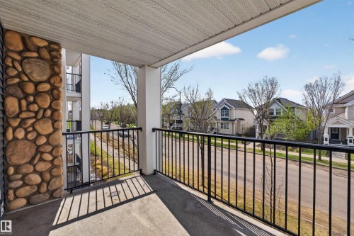Balcony space featuring a concrete floor, stone column, and black metal railing - 215 6084 Stanton Drive, Edmonton, AB - Outdoor With Balcony With Exterior