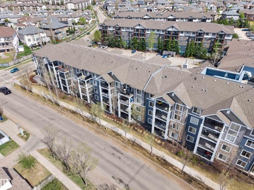Multi-level residential building featuring a combination of blue siding and stone facade - 215 6084 Stanton Drive, Edmonton, AB - Outdoor