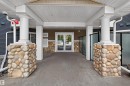 Covered entryway featuring large stone-clad columns supporting white fluted pillars - 215 6084 Stanton Drive, Edmonton, AB  -  