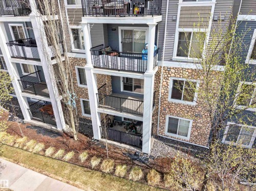 Multi-story residential building featuring balconies with black metal railings and white support columns - 215 6084 Stanton Drive, Edmonton, AB - Outdoor With Balcony