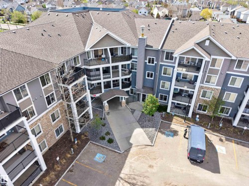 Multi-story residential building featuring balconies, a covered entrance, and visible parking - 215 6084 Stanton Drive, Edmonton, AB - Outdoor