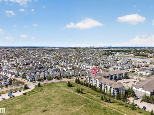 Contemporary multi-story building featuring balconies and a large surface parking area - 215 6084 Stanton Drive, Edmonton, AB - Outdoor With View
